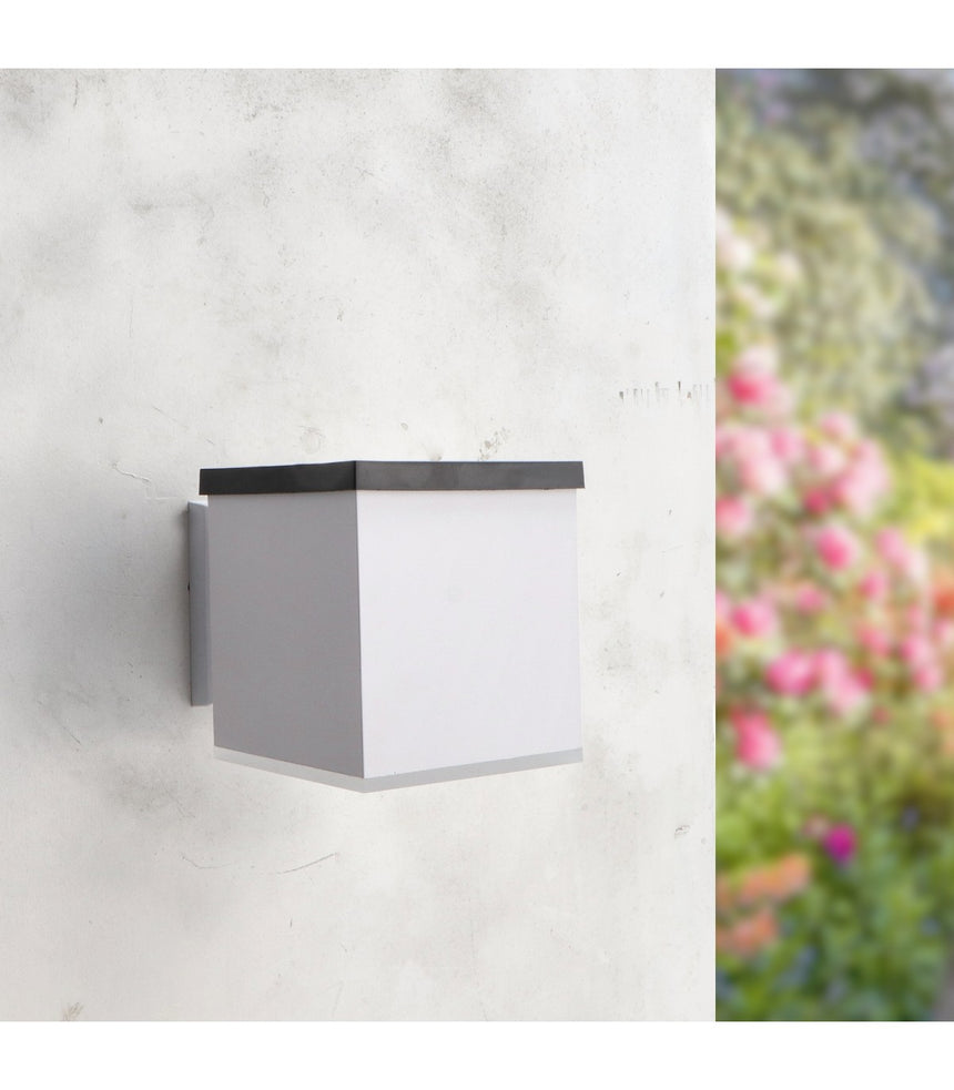 Aplique solar LEDME Jano LM6439 blanco instalado en una pared exterior, vista de día