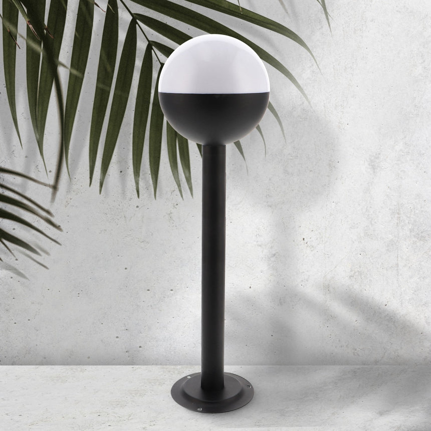 Baliza de exterior LEDME Cam Plus LM7315 negra vista completa en un jardín de día