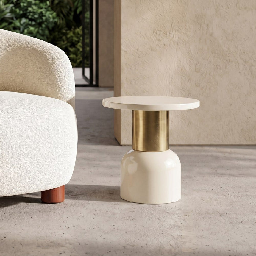 Mesa auxiliar IXIA 616768 junto al sofá, tablero circular blanco y pie dorado