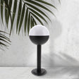 Baliza de exterior LEDME Cam LM7314 negra vista completa en un jardín de día