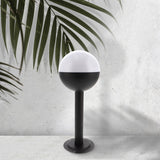 Baliza de exterior LEDME Cam LM7314 negra vista completa en un jardín de día
