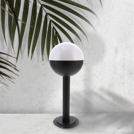 Baliza de exterior LEDME Cam LM7314 negra vista completa en un jardín de día