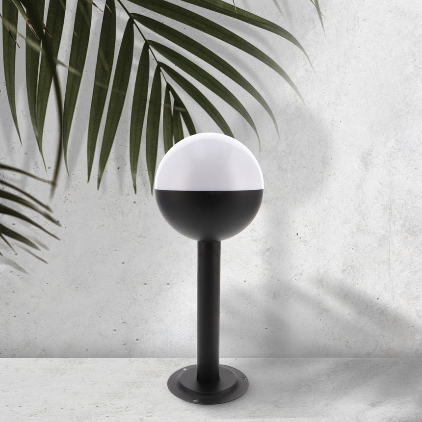 Baliza de exterior LEDME Cam LM7314 negra vista completa en un jardín de día