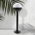 Baliza de exterior LEDME Cam Plus LM7315 negra vista completa en un jardín de día