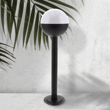 Baliza de exterior LEDME Cam Plus LM7315 negra vista completa en un jardín de día