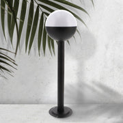 Baliza de exterior LEDME Cam Plus LM7315 negra vista completa en un jardín de día