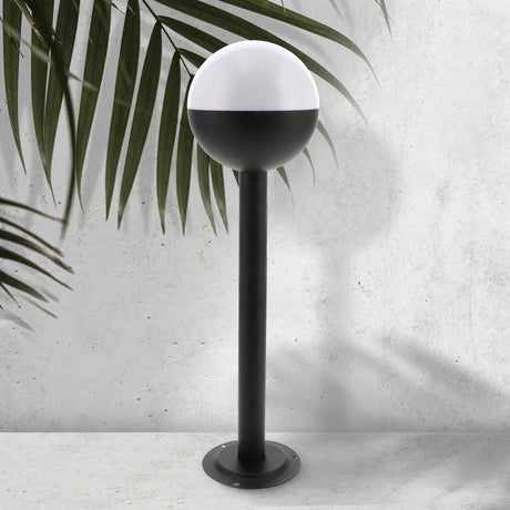 Baliza de exterior LEDME Cam Plus LM7315 negra vista completa en un jardín de día