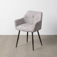 Silla IXIA 615419 tapizada jaspeado gris y blanco con brazos y patas negras, vista completa ambientada con pared y suelo