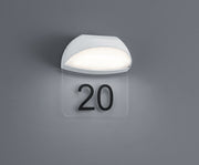 Aplique de exterior Trio Muga 228360101 blanco, iluminado sobre pared con placa transparente para numeración